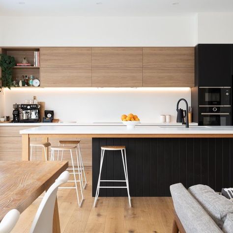 CompleteKitchens on Instagram: "The warm Prime Oak and cool Absolute Matt Black cabinetry work together to create a warm and modern feel. Milky white Palm Shade Caesarstone was chosen for the benchtop and splashback, which perfectly “disappear” in the space to provide the balance and contrast. The island’s support legs and frame are made of Tasmania Oak timber, stained to match the flooring, adding a sense of cohesion and sophistication to this edgy and modern kitchen space. #kitchendesigni White And Timber Kitchen, Hampton Kitchen, Black Cabinetry, Tan Kitchen, Prime Oak, House Renos, Modern Black Kitchen, Timber Kitchen, Black Kitchen Island