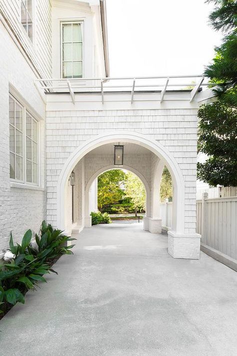 A white shingled home boasts a concrete driveway that leads to a white port cochere lit by a glass and bronze lantern. Porte Cochere, Carport Designs, Shingle Siding, Concrete Driveways, Casa Exterior, Transitional House, Dream House Exterior, Driveway, Future House