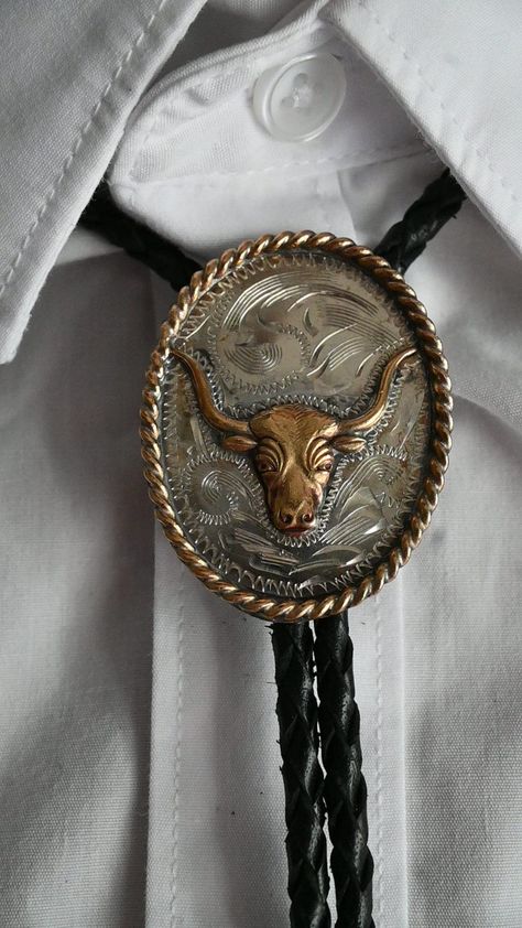 Embrace the spirit of the American West with our Longhorn Bolo Tie for Men. Crafted with attention to detail, this iconic accessory features a striking longhorn emblem, symbolizing strength and resilience. Made for the modern cowboy, each tie exudes rugged charm and timeless style. Whether you're wrangling cattle or strolling through the city streets, this bolo tie adds a touch of Western flair to any outfit. Elevate your look with the symbol of frontier heritage and make a statement with our Lo Elegant Cowboy Outfit For Men, Bolo Tie Groom, Chic For Men, Bolo Tie Men, Cowboy Accessories, Tie Outfit, Modern Cowboy, Cow Boys, Mens Western