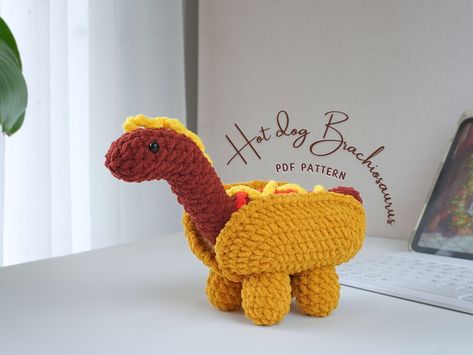 PRODUCT YOU WILL RECEIVE IS A PDF FILE WITH ENGLISH INSTRUCTIONS, NOT A PHYSICAL PRODUCT This pattern stretches a Brachiosaurus into a hot dog bun, adorned with classic toppings for a quirky craft piece.  (Inspired by @delidinoworld) 🔻 How to download your PDF after purchase: https://help.etsy.com/hc/en-us/articles/115013328108-How-to-Download-a-Digital-Item?segment=shopping ✔️ Finished pattern size: Brachiosaurus :  13 cm x 21 cm~5.1 inches x 8.3 inches. ✔️ When purchasing the combo, you will receive a PDF file that includes 4 dinosaur patterns and a bonus volcano crochet tutorial. This file will guide you through the steps, types of stitches, and illustrations to assist in this process. ✔️ In the amigurumi crochet instructions, you can find a list of materials that you need to prepare, Brachiosaurus Crochet, Dinosaur Crochet Pattern, Dinosaur Crochet, Crochet Pattern Amigurumi, Fun Crochet Projects, Crochet Instructions, Diy Crochet Projects, Crochet Hook Sizes, Loom Knitting