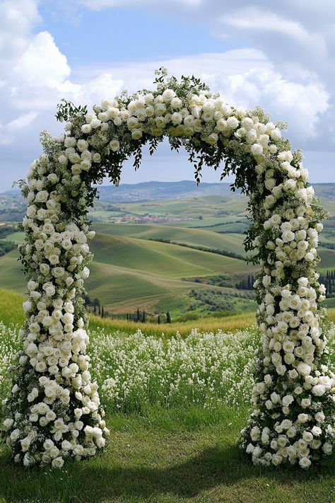 Stunning floral arch with a scenic countryside backdrop. Get enchanted by wedding decor ideas that remain elegant across the ages while impressing even the pickiest Aunt Mildred. Wedding Arches With Flowers, White Floral Arch, Timeless Wedding Decor, Wedding Arches Outdoors, Floral Archway, Twinkle String Lights, Wedding Decor Ideas, 2025 Wedding, Wedding Set Up