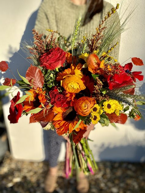 Dyed sunflower, red roses, red poppy, dahlias and fall leaves make the perfect free form fall bridal bouquet. Red Sunflower Bouquet, Dark Sunflower Bouquet, Wild Flower Fall Bouquet, Red Poppy Bouquet, Stardew Wedding, Red Sunflower Wedding, Dark Red Wedding, Sunflower Floral Arrangements, Zion Wedding