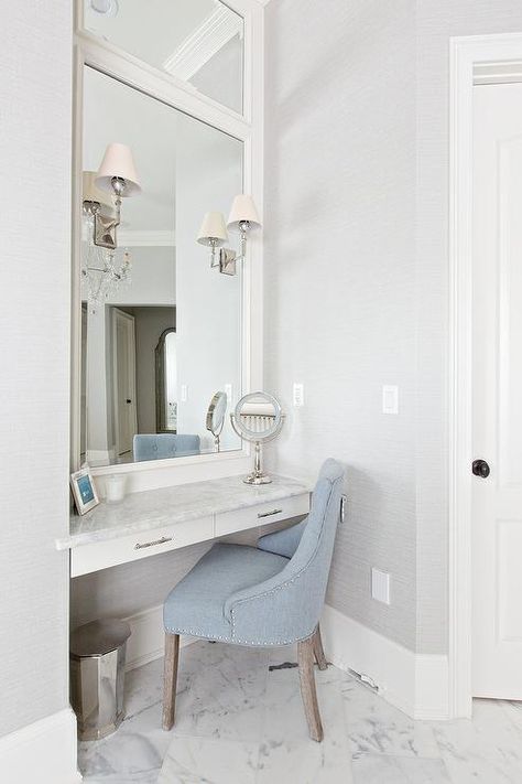 A blue vanity chair sits on marble floor tiles in front of a white floating makeup vanity accented with polished nickel pulls and a gray and white marble countertop fixed beneath a white framed vanity mirror. Makeup Nook, Awesome Mirrors, Floating Makeup Vanity, Makeup Vanity Ideas, Vanity Nook, Mom Bedroom, Diy Makeup Organizer, Diy Vanity Mirror, Vanity Inspiration