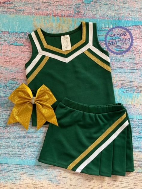 Cute girls cheerleading uniform!  Great for spirit days, pep rallies and sporting events!  This can be customized for your team and is available in multiple color selections.   Set included skirt and shell & mascot embroidered across the front. Bow is sold separately here: https://www.etsy.com/listing/1709445496/bulldogs-bow-black-gold-bulldogs-bow?click_key=916bd370755ac7b85ceaca90468eb28f98567936%3A1709445496&click_sum=1b5c64d2&ga_search_query=bow&ref=shop_items_search_5&sts=1 Uniform Color: Hunter Green with metallic gold/white trim Need something custom?  Message me with your requests! Spirit Days, Sports Uniform, Cheer Uniforms, Cute Cheerleaders, Cheerleader Costume, Cheerleading Uniforms, Football Uniform, Cheer Uniform, Cheer Girl