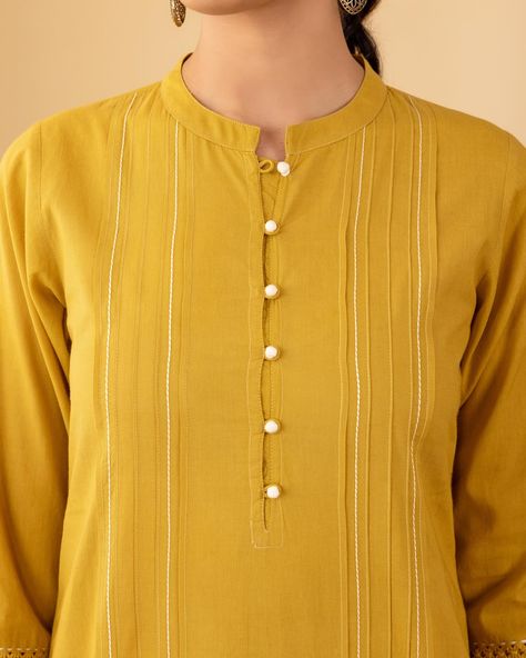 ~BASICS~ Everyday Essentials - New Arrivals! Mustard exudes warmth in this graceful kurta which has an artful richness of tucks, pleats and couching. The sleeves are highlighted with elegant ladder lace and bands of tucks and gudri edging. [ Cottons Jaipur, Cotton, Basics, Everyday, Essentials, New Arrivlas] #cottons #cottonsjaipur #newarrivals #basics #everday #essentials #dailyfits #confort #cottonkurtas #breathablefabric #handcrated #solidkurtas #solid #monochrome #cottonsuits #daywea... Band Neck Designs For Kurtis, Pleated Kurti Designs, Cottons Jaipur, Kurti Ideas, Girls Designer Dresses, Neck Designs For Suits, Cord Set, Long Kurti, Kurta Dress