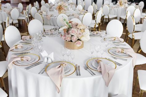 This wedding table setup exudes sophistication and elegance! The white polyester tablecloth and beige cloth dinner napkins provide a classic look for the stunning centerpiece - a brown box brimming with gorgeous blush and ivory silk roses. Each table setting is perfectly curated with small plain charger plates on top of gold-rimmed charger plates, clear long-stemmed wine glasses, and shiny silver plastic utensils. Every detail has been considered to make this wedding unforgettable. Event Decor Ideas, Party Decorations Table, Wedding Table Setup, Plastic Utensils, Decorations Table, Bay Wedding, Sophisticated Wedding, Brown Box, Ivory Silk