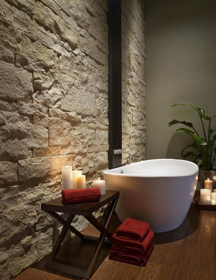 contemporary light stone wall, calming home spa, free standing white bathtub, candles, dark wood floor Cladding In Bathroom, Bathroom Stone Wall, Popular Bathroom Designs, Asian Bathroom, Bathroom Stone, Stone Accent Walls, Beautiful Bathroom Designs, Modern Bathtub, Zen Bathroom