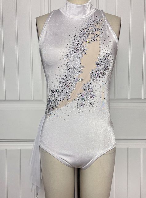 "Snow Angel" Immerse yourself in the serene beauty of winter with this sparkling white skirted leotard that evokes the tranquility of a snow-covered landscape.  ONE OF A KIND / Ready to Ship SIZE: MEDIUM - Size M measurements:  bust 37" / waist 31" / hips 40" / girth (torso) 60.5" - Size Chart: see last photo DETAILS: - Fully lined for support & comfort - High stretch garment built for acrobatic/heavy movement - All seams reinforced for extra durability - Full coverage brief-cut booty - Keyhole open back with clasp closure - Asymmetrical mesh handkerchief skirt at right hip - Asymmetrical faux cutout with embroidered silver applique embellishments topped with hundreds of hand-placed crystals for extra sparkle Handmade with love in Rhode Island, USA Sparkly Leotard, Rhinestone Leotard, Majorette Outfits, Aerial Circus, Silver Applique, Leotard Dance Costume, Solo Dance Costumes, White Leotard, Solo Dance