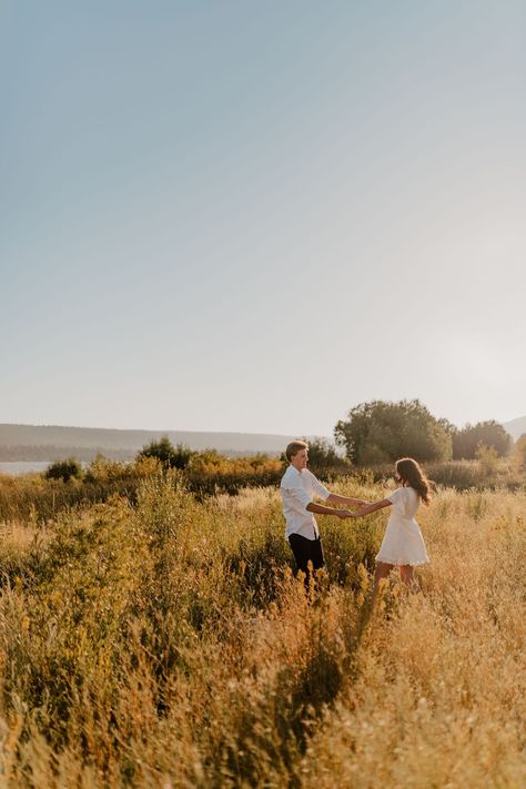 Couple sitting on the ground kissing and cuddling with each  other during their engagement session. Fall Sunset Engagement Pictures, Fall Golden Hour Couples Shoot, Outside Couples Photoshoot, Golden Hour Engagement Shoot, Engagement Photos Grass Field, One Year Couple Pictures, Running Engagement Photos, Engagement Photos Golden Hour, Couples Field Photoshoot