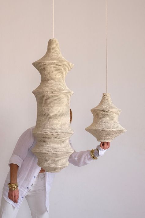 Two handcrafted crochet pendant lights suspended with a woman dressed in all white in the background. Modern Moroccan Design, Natural Chandeliers, Crochet Pendant, Crochet Lamp, Affordable Lighting, Lighting Installation, Internal Design, Handmade Lamps, Marrakech Morocco