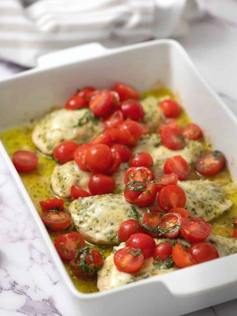 This Easy Pesto Chicken is an easy knock-out dinner recipe. Made with chicken, pesto, cheese, and topped with fresh tomatoes this simple baked chicken recipe is perfect for a low-carb dinner any night of the week. Easy Pesto Chicken, Simple Baked Chicken, Baked Pesto Chicken, Baked Chicken Recipe, Pesto Cheese, Foil Dinners, Baked Chicken Recipes Easy, Chicken Pesto, Carb Dinner