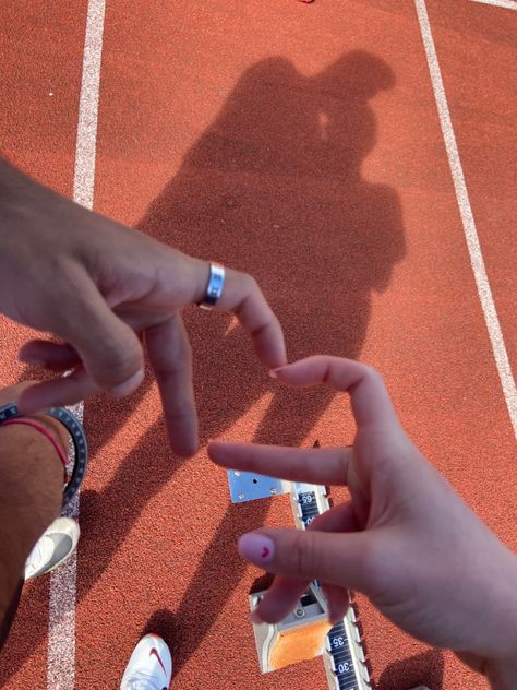 on red track with hand hearts Couples Running Together, Track Couple Pictures, Track And Field Couples, Couple Athlete, Track Couple Goals, Running Couple Aesthetic, Couples Running Aesthetic, Sport Couple Aesthetic, Couple Running Aesthetic