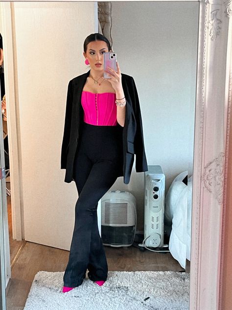 a mirror photo with a woman wearing black flared trousers from prettylittlething , bright pink pointed heels, bright pink corset and a black blazer draped over her shoulders. This is a night time outfit or a sophisticated outfit that would be best for date night , business parties and any sophisticated occasion. This look is perfect for a  date night or a night out in town or even a nice evening meal Black And Pink Style Outfit, Corset And Pants Outfit Formal, Black Outfit With Pink Accessories, Dark Pink And Black Outfit, Hot Pink Business Outfit, Purple Corset Top Outfit, Pink Top Black Pants Outfit, Hot Pink Corset Outfit, Pink Corset Top Outfit