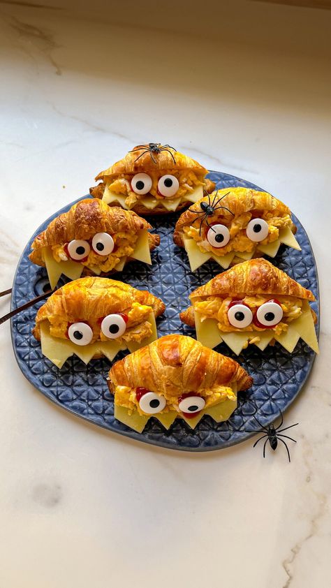 This fun and tasty recipe transforms a simple croissant into a whimsical creature, complete with cheesy fangs and edible candy eyes. Halloween Croissant Ideas, Halloween Kids Breakfast, Halloween Croissants, Spooky Halloween Dessert Ideas, Halloween Sandwiches Parties Food, Halloween Kids Food Ideas, Halloween Kid Food, Halloween Aesthetic Food, Halloween Eats Ideas