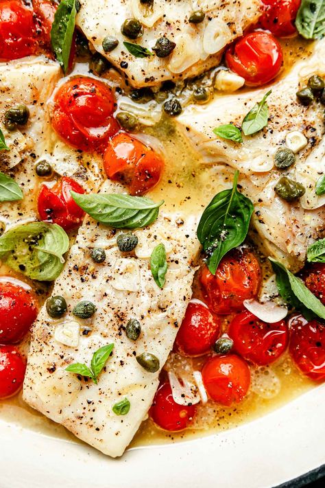 Ready in 20 minutes, White Wine Steamed Fish with Burst Tomatoes is a low-effort dinner dream! Layer white fish fillets in a skillet with cherry tomatoes, capers, & white wine, then the stove does all the work! The fish gently steams until flaky & tender, while the wine reduces into a white wine butter sauce. Serve with fresh herbs, rice, & veggies for a fast, fresh, & healthy meal! (Pescatarian) #steamedfish #howtosteamfish #steamedfishrecipes #fishrecipes #pescatarianrecipes #easydinneridea Burst Tomatoes, Wine Butter Sauce, Steamed Fish Recipes, White Wine Butter Sauce, Wine Butter, Healthy Sauces, Delicious Seafood Recipes, Fish Fillets, Steamed Fish