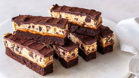 When you want a truly rich dessert, you have to go straight to the top. No more millionaires and billionaires; that's just not rich enough for your tastebuds. No, you have got to have Trillionaire Bars! Trillionaire Bars layer fudgy brownie, salty, buttery caramel, melt-in-your-mouth and safe-to-eat cookie dough, and a smooth, luscious, chocolate ganache one on top of the other; it's all of the best sweet treats you desire all at once. This dessert needs a monocle and a top hat, it's so ... Trillionaire Bars, Stracciatella Soup, Bar Desserts, Cookie Dough To Eat, Tasty Pastry, Rich Desserts, Fall Festivities, Lobster Recipes, Soft Caramel