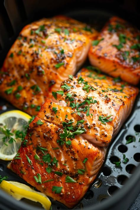 Grilled salmon fillets seasoned with herbs and lemon slices. Air Fried Blackened Salmon, Best Damn Air Fryer Salmon, Ninja Foodie Salmon Recipes, Salmon Marinade Air Fryer, Salmon In The Air Fryer Recipes, How Long To Cook Salmon In Air Fryer, Crispy Salmon Air Fryer Recipes, Salmon Steaks In Air Fryer, Frozen Salmon Air Fryer Recipes