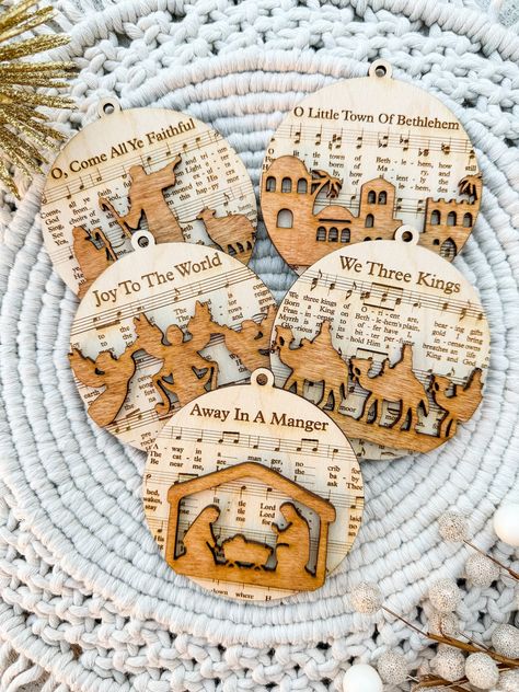 Enhance your holiday decorations with this Custom Laser Cut Wooden Nativity Scene Ornament Set. These ornaments combine the beauty of a nativity scene with the magic of Christmas music, making them a unique and cherished addition to your festive decor. Whether for your own home or as a thoughtful gift, these ornaments are sure to bring joy and warmth to your holiday celebrations. Buy as a set of 5 or individual ornaments! Christian Crafts To Sell, Religious Christmas Crafts, Sheet Music Ornaments, Wooden Nativity, Christmas Bazaar, Religious Ornaments, Music Ornaments, Christian Ornaments, Engraving Ideas