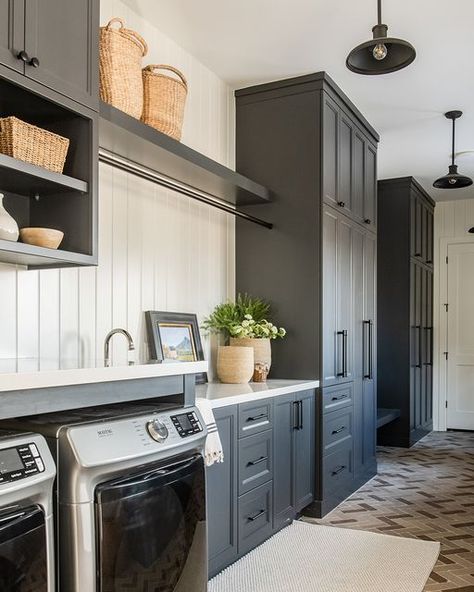 Remedy Design Firm on Instagram: "Have you ever heard of his and hers garages? This laundry room is right off "his" garage, so we wanted to bring in masculine elements by selecting an industrial lighting and a brick floor. We added a countertop above the washer and dryer to maximize folding space. Furniture & accessories: @elementsbyremedy Builder: @purehavenhomes Photography: @rebekahwestoverphotography #foxdenproject #foxdenhome #foxden #laundryroom #laundryroominspo #laundryroominspiratio Laundry Room And Butlers Pantry Combo, Large Laundry Room Ideas Layout, Laundry Room Cabinet Design, Mudroom Laundry Room Entryway, Long Laundry Room Ideas Layout, Laundry And Utility Room Combo, Washer Dryer Mudroom, Washer And Dryer In Garage Ideas, Narrow Mudroom Laundry Room Ideas