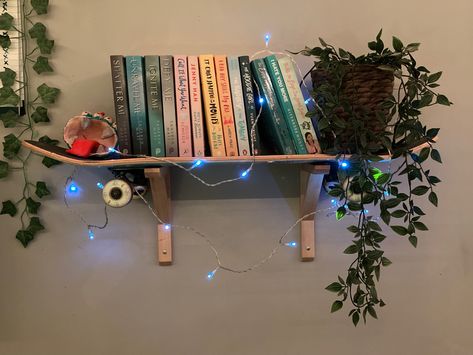 A skateboard used as a shelf to hold books and plant. Skateboard Shelf Ideas, Skate Board Shelf, Room Decor Skater Aesthetic, Skatergirl Room, Skateboard On Wall Decor, Skater Girl Bedroom, Skater Girl Room Ideas, Skater Bedroom Aesthetic, Skater Aesthetic Room