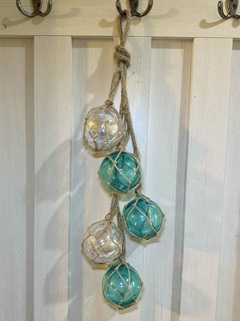 A glass fishing float wall hanging Dollar Tree DIY Beach Theme Bathroom Diy, Dollar Tree Nautical Diy, Nautical Diy Crafts, Beach Theme Bathroom Decor, Rustic Beach Decor, Dollar Tree Diys, Sea Things, Beach Crafts Diy, Home Decor Coastal