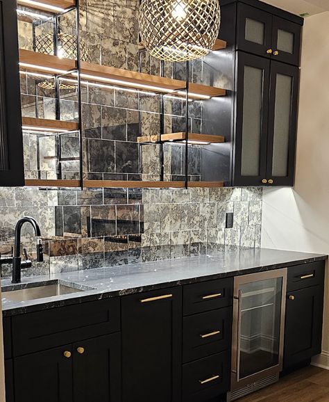 We love a well-designed wet bar that blends practicality and style! Whether you’re entertaining guests or relaxing with family, this mini bar adds convenience and elevates your space. A perfect addition to any basement renovation!  #HomeRenovation #BasementDesign #WetBar #InteriorDesign #BasementRenovation #HomeBar #EntertainingAtHome #CustomHomeDesign #LuxuryLiving #HomeInspiration #DIYHome #ModernHome #HomeImprovement #InteriorStyling #HomeGoals Basement Bar Modern, Wet Bar Backsplash Ideas, Mirror Backsplash Bar, Black Wet Bar, Small Wet Bar Ideas, Bar In Basement, Wet Bar Backsplash, Small Bar Ideas, Backsplash Bar