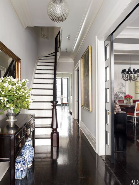 The foyer of Brooke Shields’s New York City townhouse, is furnished with an 1860s Chinese desk adorned with decorative blue-and-white vessels. Townhouse Decorating, Georgiana Design, Hiasan Dalaman Rumah, Reka Bentuk Dalaman, New York Townhouse, Foyer Staircase, Casa Country, New York Homes, Dark Wood Floors