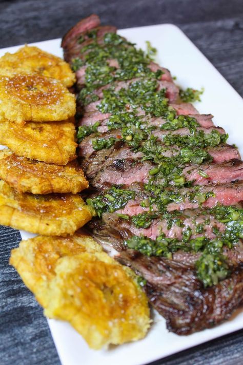 Using a cast iron grill pan, you can create a perfectly Grilled Flank Steak from the comfort of your home kitchen. Topped with Chimichurri Sauce and served with Fried Plantain/Tostones, this recipe is sure to have your guests begging for more. #thedailyspeshyl #grilledflanksteak #tostones #steakdinner | thedailyspeshyl.com Plantain Tostones, Grilled Plantains, Fried Plantain, Banane Plantain, Flank Steak Recipes, Gourmet Grilling, Cast Iron Grill Pan, Iron Grill, Grilled Flank Steak