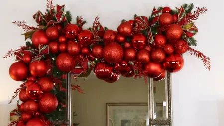 92 Extraordinary Christmas garland ideas - Craftionary Red Christmas Garland Ideas, Bulb Garland Christmas, Christmas Ball Garland Decorating Ideas, Christmas Balls Garland, Christmas Garland Diy Outdoor, Christmas Bulb Garland, Red Christmas Garland, Christmas Ball Garland, Christmas Garland Ideas