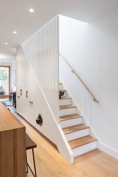 Kitchen, Refrigerator, Wood Counter, Marble Counter, White Cabinet, and Light Hardwood Floor CAB Architects deftly hid appliances, pantry storage, and a litter box for the owners' two cats in the cabinetry beneath this staircase. Edwardian House Renovation, House Renovation Projects, Staircase Storage, Stairs Design Modern, Edwardian House, Home Stairs Design, Modern Stairs, Understairs Storage, Modern Staircase