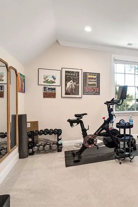 This bright and airy home gym has everything you need for a full-body workout at home. The space features a Peloton bike, a treadmill, a set of dumbbells, and a large mirror. The natural light and clean lines make the room feel inviting and energizing. #homegym #fitness #workout #exercise #treadmill #peloton #bike #dumbbells #mirror #interiordesign #homedecor #dreamhouse #furniture #room #roomdecor #roomrefresh #diseñodeinteriores #ideiasdedecoração Mirror In Home Gym, Home Office Gym Combo, Office Gym Combo, Peloton Gym, Exercise Treadmill, Home Gym Design Luxury, Bright And Airy Home, Small Home Gym Ideas, Airy Home