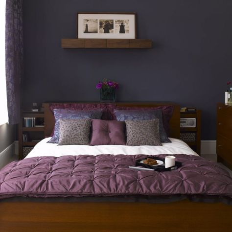 Create a grown-up bedroom scheme with a co-ordinating colour palette in midnight blue, deep plum and charcoal. Paint the main wall in a flat, matt shade to showcase the bed and soft furnishings with furniture kept neat and unfussy in a sleek dark wood veneer. Gothic Dungeon, Midnight Blue Bedroom, Purple Bedroom Design, Tan Shades, Bedroom Eclectic, Small Bedroom Inspiration, Navy Blue Bedrooms, Night Tables, Purple Bedrooms