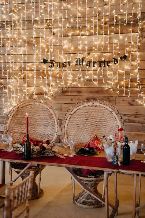 Wedding high table with wicker chairs by gothic wedding tablescape with deep red table runner, pampas grass and dried flower table centrepieces, red tapered candles in black bottles, fairy light wall and black just married sign Table For Bride And Groom, Fairy Light Wall, Red Bridesmaids Dresses, Red Table Runner, Wedding Sweetheart Table, Wedding Top Table, Wicker Peacock Chair, Gold Bridal Crowns, Peacock Chairs