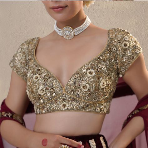 The classic maroon silk velvet lehenga features a light golden border and a heavy metallic sequins zardozi border. The lehenga is paired with a full zardozi embroidery sweetheart neck blouse. The set is completed with a maroon silk Georgette dupatta cum cape, which features metal sequins and a dabka zardozi border. #RichaAhluwalia #festivewear #bridalcouture #handcraftedclothing #indianwedding #bridesofinstagram #bridetobe #bridalwear #indianweddingdress Velvet Lehenga Blouse, Zardozi Border, Sweetheart Neck Blouse, Golden Lehenga, Golden Blouse, Blouses Designs, Velvet Lehenga, Zardozi Embroidery, Golden Border