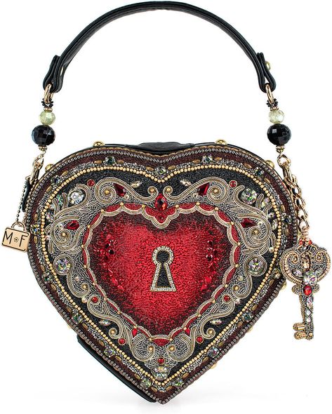 Mary Frances Embrace Top Handle Bag Spread love wherever you go with our heart-shaped locket handbag! Complete with a removable key charm and intricate filigree design, this top-handle bag is the perfect accessory for any occasion. DIMENSIONS: 8.5 x 2.25 x 8", Strap Length: 16.25", Strap Drop: 5.5", FEATURES: Non-removable top-handle, magnet closure, inside pocket, fits a phone, vegan leather THIS IS A HANDMADE ITEM, EACH ONE AN INDIVIDUAL WORK OF ART. SLIGHT VARIATIONS MAY OCCUR. I am a authorized retailer for Mary Frances Handbags  Must be returned as received in new condition as received with all the tags and wrappings ....Thank you   Enjoy and please leave me some great feedback! Mary Frances Handbags, Novelty Handbags, Novelty Purses, Big Handbags, Mary Frances, Purse Gift, Purse Brands, Novelty Bags, Best Handbags