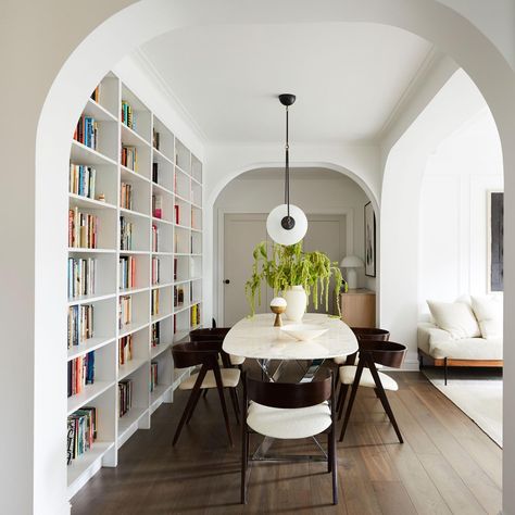 Dining table next to a wall of bookshelves in a renovated prewar apartment full of archways, Brooklyn, New York City [3275×3275] - Imgur Prewar Apartment, Architecture Restaurant, Home Library Design, Wall Bookshelves, Home Libraries, New York Apartment, Built In Bookcase, Plywood Furniture, The Dining Room