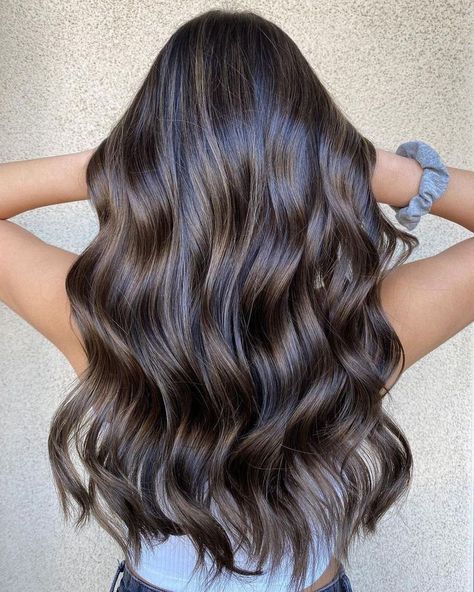 This hairstyle features glossy, wavy layers with a rich brunette balayage, creating a soft and natural transition of color from roots to ends. The delicate waves add movement and texture, while the balayage provides subtle dimension, giving the hair a fuller, more voluminous appearance. Chocolate Brown Balayage, Trendy Balayage, Dark Hair Color Ideas, Dark Hair Color, Hair Color Ideas For Winter, Wavy Layers, Rich Brunette, Brunette Balayage, Black Chocolate