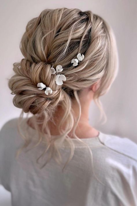 Elegant twisted updo with delicate white floral accessories creates a romantic bridal hairstyle. Light blonde tones add a soft touch to the intricate texture of the hair. Perfect for special occasions.  // Photo Credit: Instagram @staciegoodwinbridalhair Bridal Hair Romantic Updo, Wedding Hairstyle Blonde, Blonde Wedding Hair Updo, Wedding Updo With Flowers, Romantic Wedding Hair Updo, Wedding Green Theme, White Wedding Guest Dresses, Cute Hair Looks, Shiny Black Hair