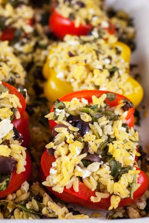 These Vegetarian Greek Stuffed Peppers make for a healthy and flavorful meatless meal! They're made with bell peppers that are stuffed with a filling prepared with orzo, spinach, Kalamata olives, feta cheese, and lemon. The peppers are baked in the oven with garlic, oregano, and olive oil until tender and garnished with fresh parsley. This dish is full of Mediterranean flavors and great for a weeknight dinner. These stuffed peppers are gluten free and made without meat! Stuffed Bell Peppers With Orzo, Orzo Stuffed Bell Peppers, Stuffed Peppers Vegetarian, Orzo Feta, Orzo Spinach, Greek Stuffed Peppers, Vegetarian Stuffed Peppers, Mediterranean Flavors, Vegetarian Main Course