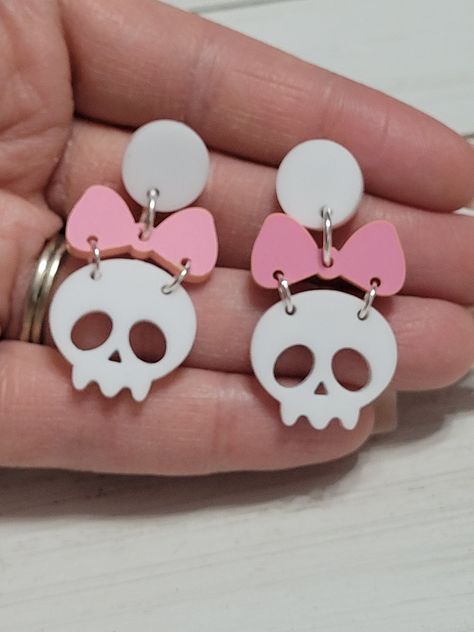 Laser cut acrylic bow skull stud earrings are 1 inch wide and 1.5 inch long with stainless steel hypoallergenic and nickel free studs. Visit here for more of our Halloween earrings or spooky earrings: https://www.etsy.com/shop/AshlaDesigns?ref=seller-platform-mcnav§ion_id=35315998 Allergies: All of our jewelry is made with hypoallergenic stainless steel or silver/gold plated findings that are nickel free. Care: Keep it dry. Remove when bathing or swimming. Store in a box or bag in a cool dry pla Laser Cut Earrings Acrylics, Laser Cut Wood Earrings, Laser Cut Sign, Girly Tattoos, Laser Cut Acrylic, Bow Earrings, Skull Earrings, Bow Design, Halloween Earrings