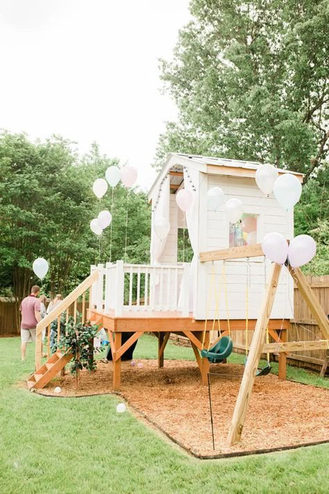 a white kids' playhouse with a porch, a ladder, swings and white balloons is a lovely idea for your garden Play Set Design Ideas, Playhouse In Backyard, Swingset Tree House, Backyard Design With Playset, Backyard Inspiration Kids, Backyard Swingset Area, Play Set Backyard, Outdoor 2nd Birthday Party Ideas, Backyard Childrens Play Area