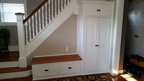 Customer was looking for a way to utilize empty space near the front door.  A combination storage bench and cabinet was designed to fit in under the stairs.  The tall cabinet has a large open space with hooks for storing kids' jackets and school backpacks, along with upper and lower storage for smaller items.  The bench provides additional storage via a flip-up top.  The top was made from reclaimed heart pine and was stained/finished to match the existing floors. Shoe Storage Cabinet With Doors, Under Stairs Nook, Room Under Stairs, Entry Storage, Stairs In Kitchen, Stairs Renovation, Bench Entryway, Stairs In Living Room, Stairs Makeover