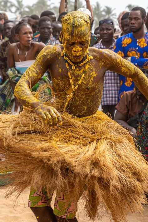 An African man in a grass skirt and covered in yellow paste dancing in front of a crowd Benin Voodoo, African Festival, Carnival In Rio, African Traditional Religions, Galle Fort, Music Singing, Grass Skirt, African Dance, Joyous Celebration