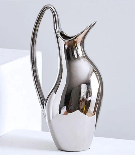 COMPLIMENTARY GLOBAL SHIPPING
 






ABOUT THIS ITEM












This stunning Vase exemplifies that less is more. Crafted by hand from ceramic, it harmonizes minimalistic, sculptural aesthetics with gentle curves, making it suitable for an array of decor styles, and it can also serve as a water jug. Bring a contemporary classic into your living space.
DETAILS

Material: Glazed Ceramic
Hue: Silver 
Dimensions Small: 24x5.5 cm (Approx. Weight: 0.68 kg. Capacity: 550 ml)
Dimensions Large: 32.5x7.7 cm (Approx. Weight: 1.4 kg. Capacity: 1200 ml)
Function: Water Jug, Vase









MAINTENANCE 
Hand wash only.

PRICE GUARANTEE



At Homeko, we are dedicated to providing you with the most exceptional luxury-style shopping experience at up to 80% off of retail prices. 



DELIVERY & RETURN POLI Steel Vase, Water Vase, Soft Geometry, Photography Buildings, Silver Jug, Steel Dining Chair, Simple Home Decoration, Ceramic Color, Silver Water