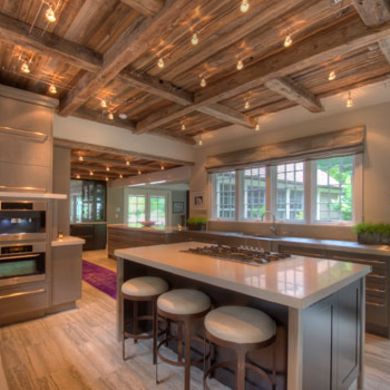 A wonderful blend of modern details and rustic charm, this kitchen features a wooden ceiling and exposed beams that draw the eye upwards, while track lighting floods the space with light. Borrow this idea: If your layout allows, install a range top in your work island to open up counter space elsewhere in the room. Track Lighting Exposed Beams, Exposed Joists, Kitchen Beams, Ceiling Inspiration, Kitchen Island With Stove, Exposed Ceiling, Exposed Beams Ceiling, Track Lighting Kitchen, Popular Kitchen Designs