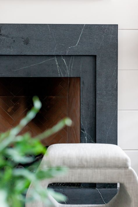 We remodeled this dated fireplace using layered soapstone and wide shiplap. We fell in love with this black, veiny soapstone slab. We also put stools in front of the fireplace for extra seating. Great idea for a fireplace makeover, fireplace design, or fireplace update. Designed by Lark Interiors, Dallas TX Soapstone Fireplace, Granite Fireplace, Fireplace Update, Fireplace Tile Surround, Black Fireplace, Interior Design Work, Fireplace Remodel, Home Fireplace, Marble Fireplaces