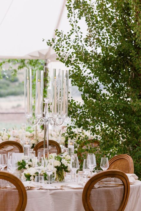 White rose, white anemone dark center, white ranunculus, white freesia, white scabiosa, white and green parrot tulips, lysimachia glass vase centerpiece trio, crystal glass candelabra round table centerpiece Glass Candelabra Centerpiece, Glass Vase Centerpiece, White Scabiosa, Round Table Centerpiece, Candelabra Wedding Centerpieces, Ranunculus White, White And Green Wedding, Candelabra Wedding, Glass Vases Centerpieces