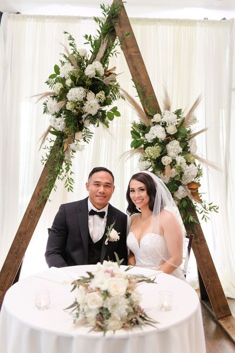 bride, groom, sweetheart table, triangle arch, boho, rustic, Fowler Studios Triangle Arch Behind Sweetheart Table, Bride Groom Table Rustic, Bride And Groom Table Flower Arrangement, Rustic Wedding Backdrop Ideas, Sweetheart Table Arch, Triangle Arch Wedding, Bridal Table Backdrop, Switzer Farm, Triangle Decor