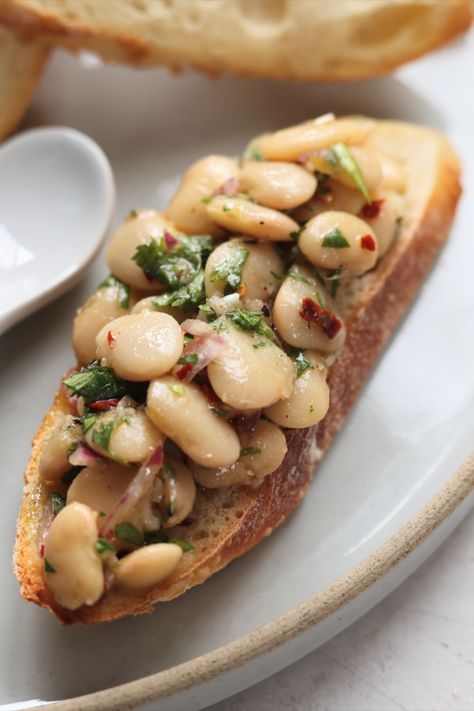 Marinaded white beans on toast White Bean Appetizer, Toasted Crostini, Cheese Platter, White Bean, Cheese Platters, Crusty Bread, White Beans, Arugula, Appetizer