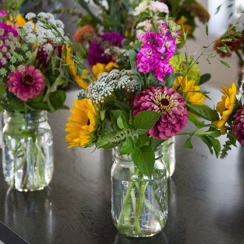 If you love the beauty that only fresh flowers can bring and are seeking an economical way to make small floral bouquets a bucket of blooms may be the perfect option. If you think you lack creativity, don't be intimidated! This step-by-step tutorial will demonstrate how to turn our bucket of blooms into ten mini mason jar bouquets. Farm Floral Arrangements, Farm Flower Arrangement, Zinnia Bouquet Mason Jars, Small Floral Arrangements Simple, Farmers Market Flowers Bouquets, Bouquet Making Party, Farmers Market Bouquet, Simple Flower Arrangements, Market Bouquets